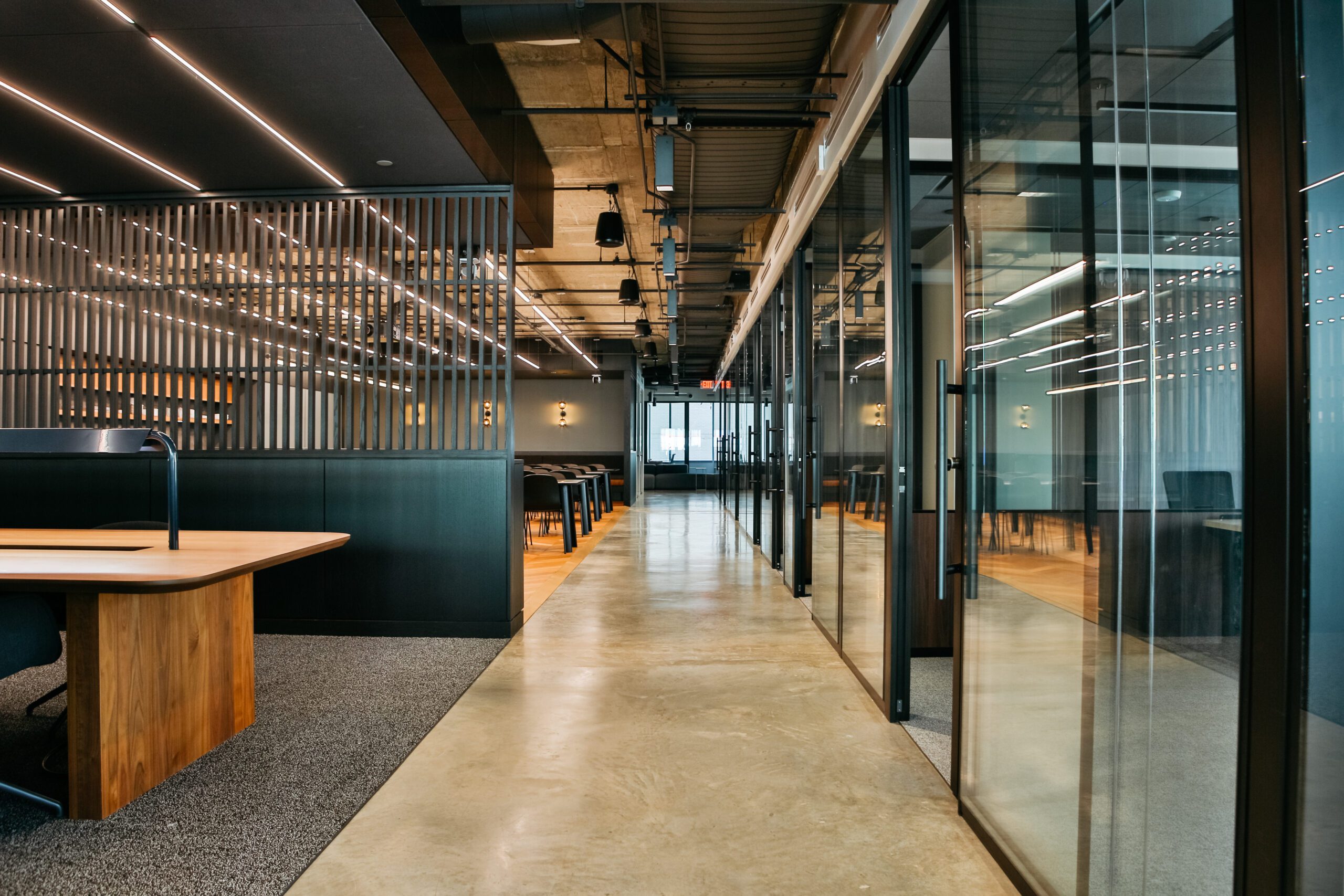 the view of a launch workplaces coworking space looking down the hall with private ofices on the right, coworking desks on the left, lots of open space and natural light, and beautiful modern design and decor