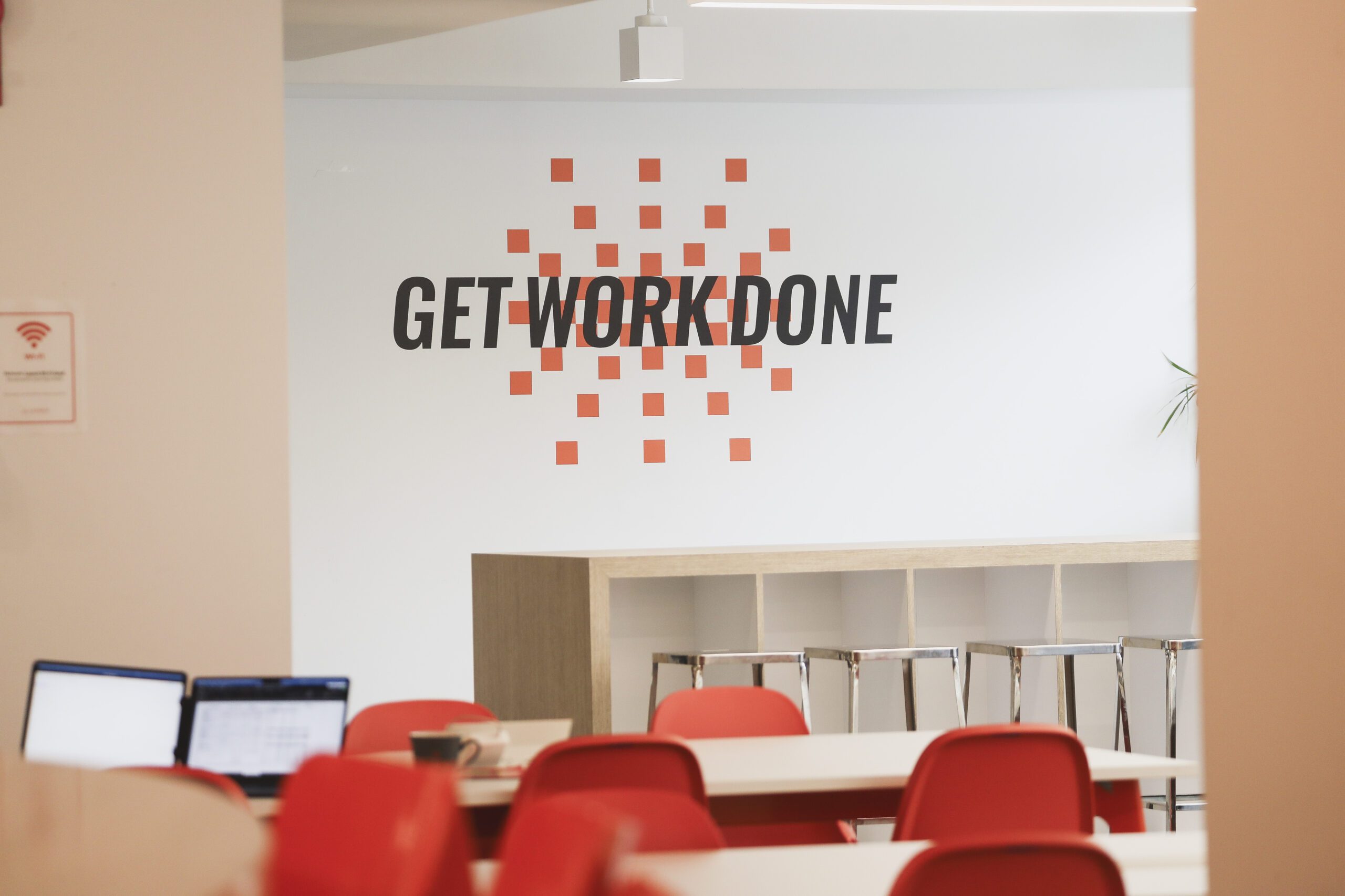 a wall inside a launch workplaces coworking space with the get work done emblem on the wall